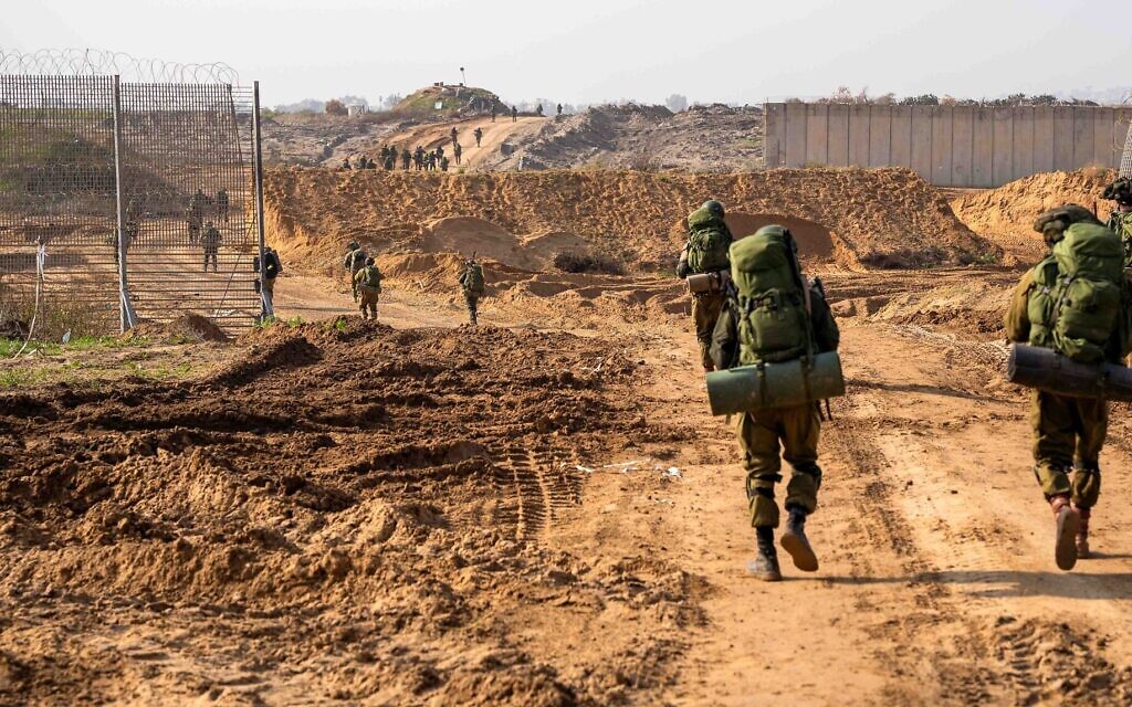 IDF troops marching past fence IDF photo
