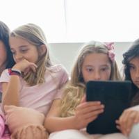 Young girls gazing at their mobile devices